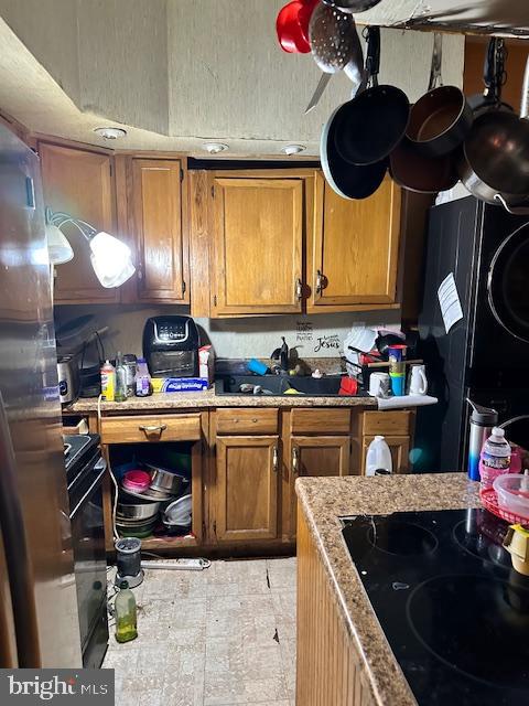 kitchen featuring light tile floors and black appliances