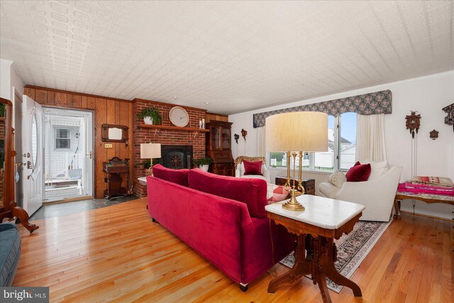 living room with wooden walls, light hardwood / wood-style floors, and a fireplace