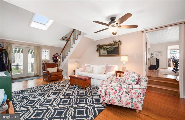 living room featuring french doors, wood-type flooring, ceiling fan, and a skylight