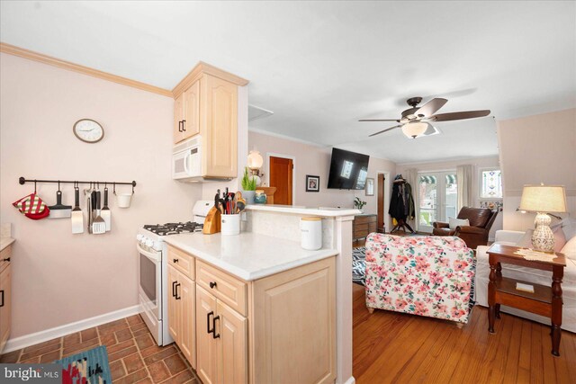 kitchen with kitchen peninsula, white appliances, ceiling fan, dark hardwood / wood-style flooring, and ornamental molding