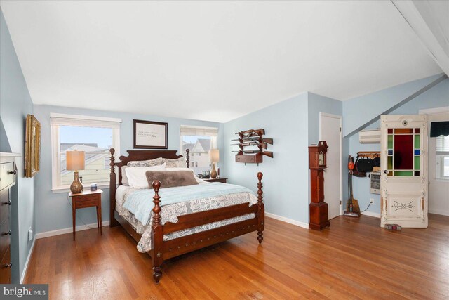 bedroom with an AC wall unit and hardwood / wood-style flooring