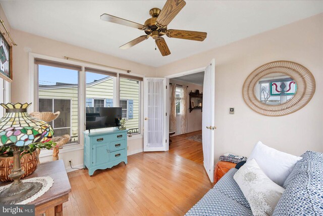 living room with ceiling fan and light hardwood / wood-style flooring