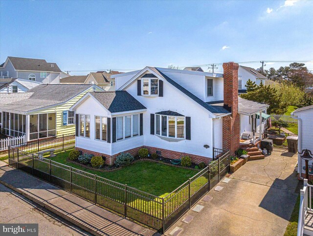 view of front of home with a front lawn and a sunroom