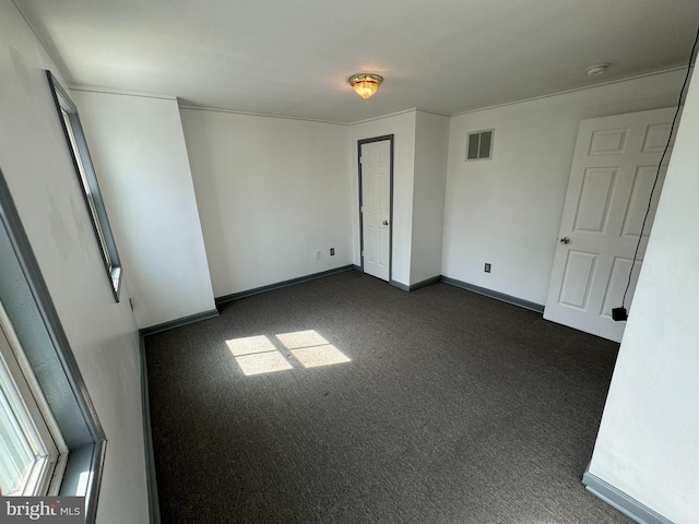 unfurnished room featuring dark colored carpet