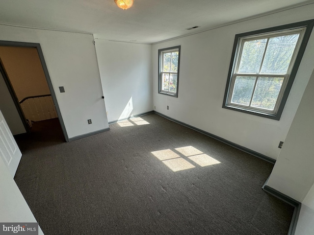 unfurnished bedroom with dark colored carpet