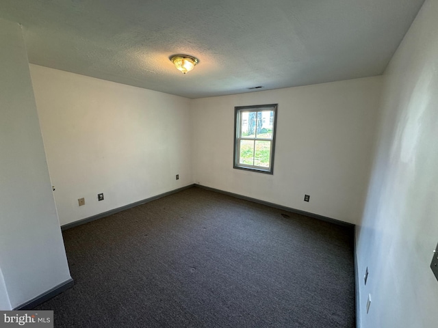 carpeted spare room with a textured ceiling