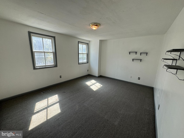 empty room with dark colored carpet