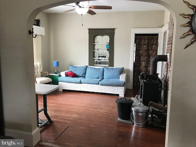 living room featuring dark wood-type flooring and ceiling fan