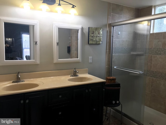 bathroom featuring an enclosed shower and double sink vanity