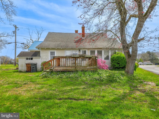 back of property with a wooden deck and a lawn