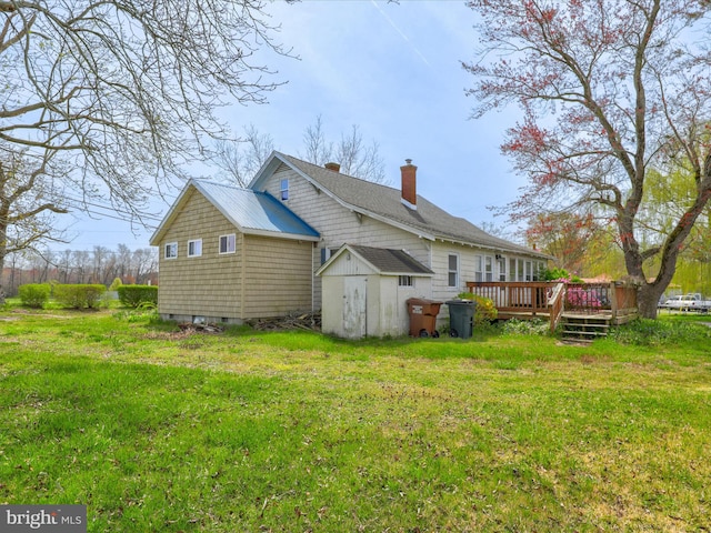 exterior space featuring a yard, a wooden deck, and a storage shed