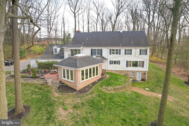 rear view of property featuring a lawn