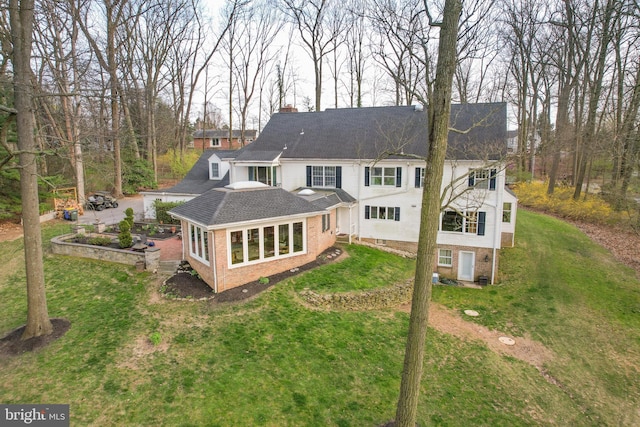 rear view of property featuring a yard