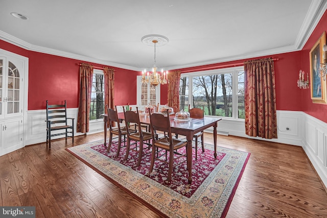 dining space featuring a notable chandelier, crown molding, and hardwood / wood-style flooring