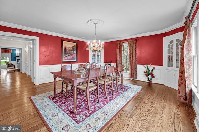 dining area featuring hardwood / wood-style flooring, ornamental molding, and a wealth of natural light