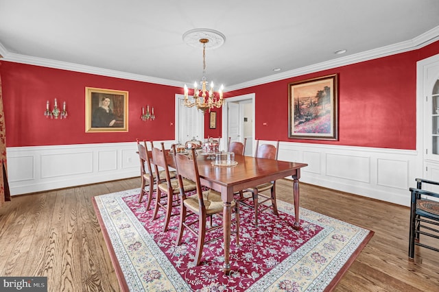 dining room featuring ornamental molding, a notable chandelier, and hardwood / wood-style floors