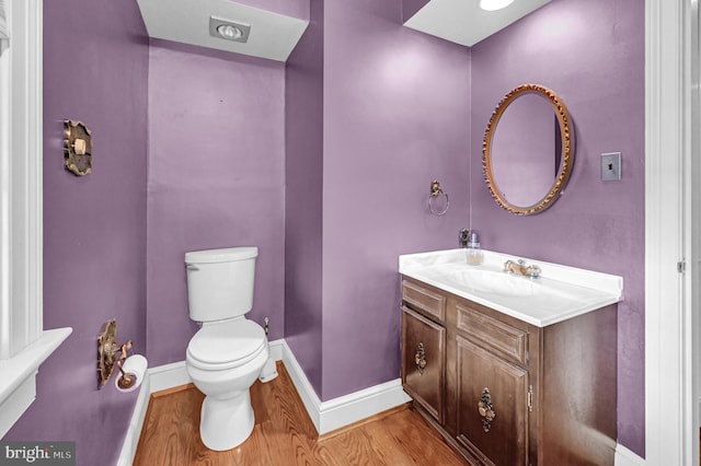 bathroom featuring vanity, toilet, and hardwood / wood-style flooring