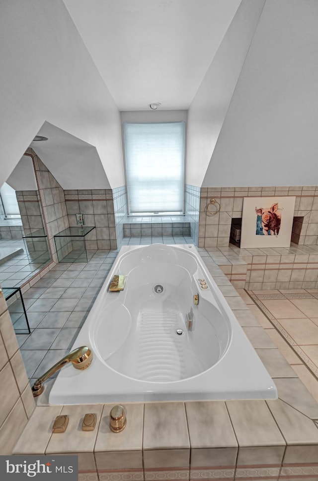 bathroom with tiled tub and tile patterned floors