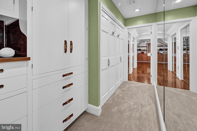 spacious closet featuring light colored carpet