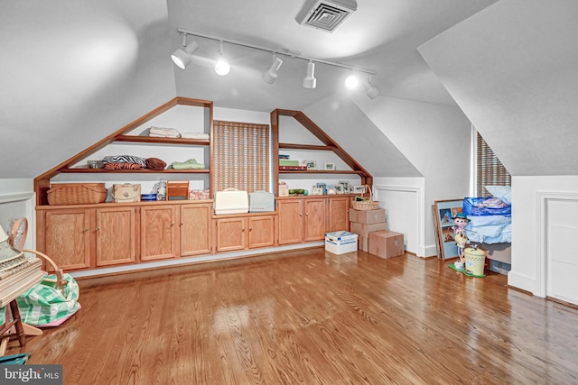 additional living space featuring lofted ceiling and light wood-type flooring