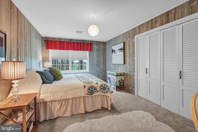 bedroom with ornamental molding, carpet floors, a closet, and wood walls