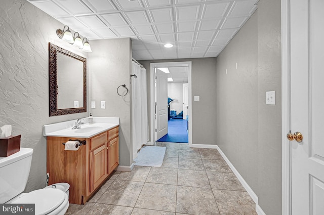 bathroom with toilet, vanity, and tile patterned floors