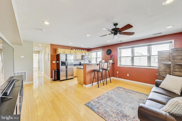 living room with light hardwood / wood-style flooring and ceiling fan