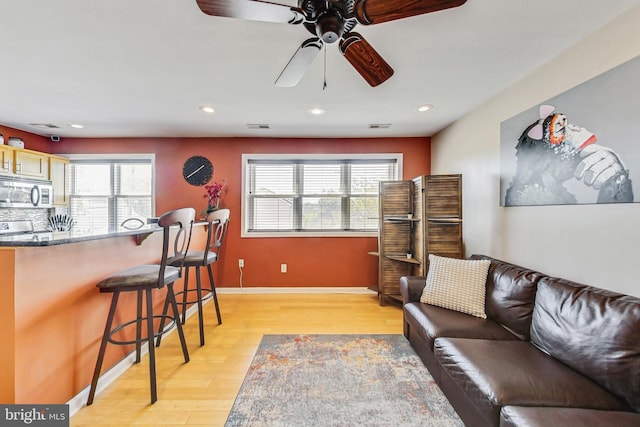 living room with a healthy amount of sunlight, ceiling fan, and light wood-type flooring