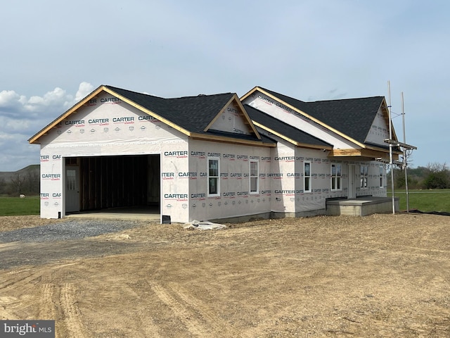 property under construction with a garage and dirt driveway