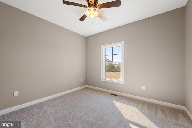 empty room with carpet flooring, ceiling fan, visible vents, and baseboards