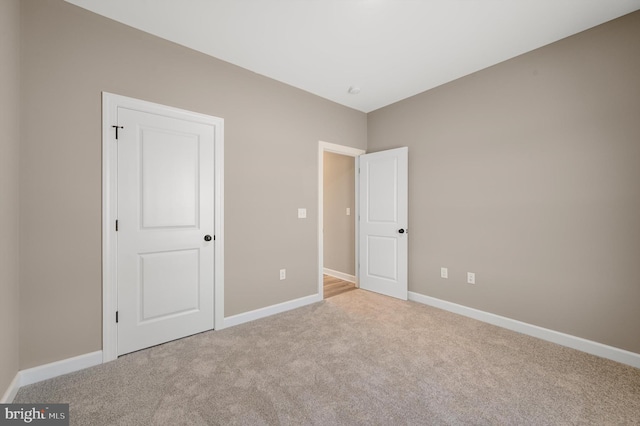 unfurnished bedroom with baseboards and light colored carpet