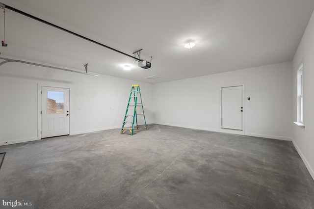 garage featuring a garage door opener and baseboards