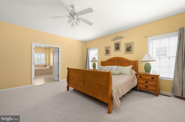 bedroom with light carpet, ceiling fan, and ensuite bathroom