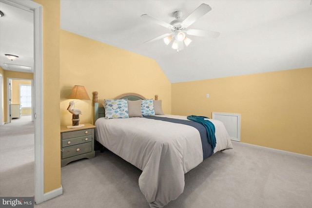 carpeted bedroom with ceiling fan and vaulted ceiling