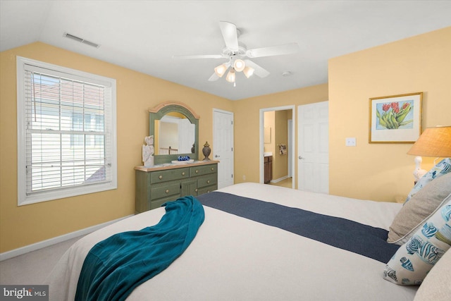 bedroom featuring ensuite bath, carpet, ceiling fan, and vaulted ceiling