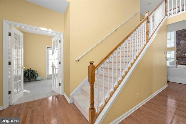 staircase with french doors and light wood-type flooring