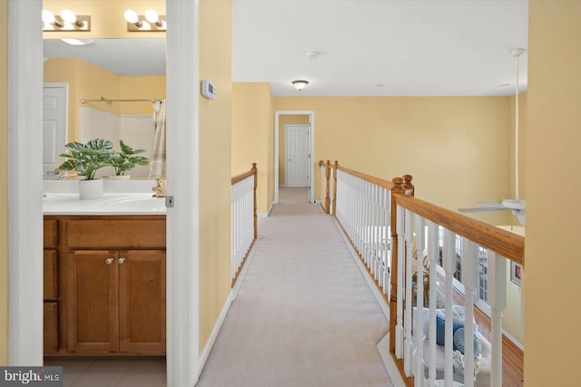 hallway with sink and light carpet