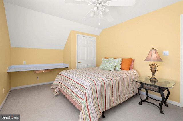 carpeted bedroom with ceiling fan and vaulted ceiling