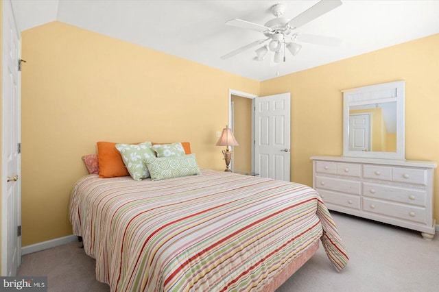 bedroom featuring light colored carpet, lofted ceiling, and ceiling fan