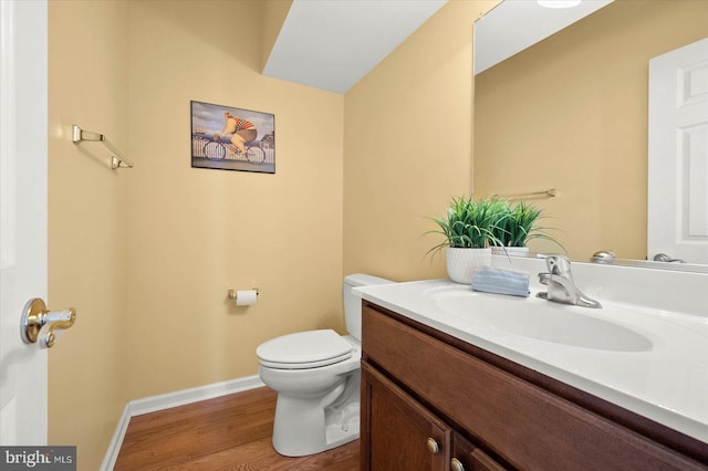 bathroom featuring wood-type flooring, toilet, and large vanity