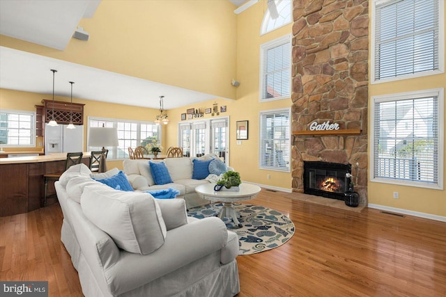 living room with wood-type flooring, plenty of natural light, and a high ceiling