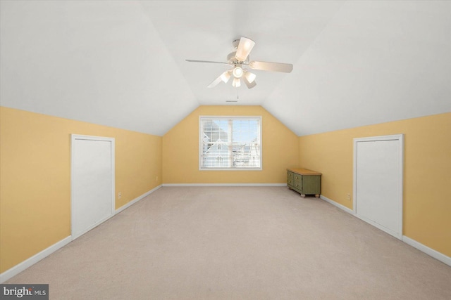 additional living space featuring light colored carpet, ceiling fan, and vaulted ceiling