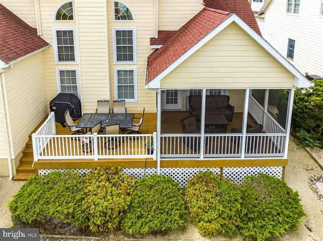 exterior space with a wooden deck and a sunroom