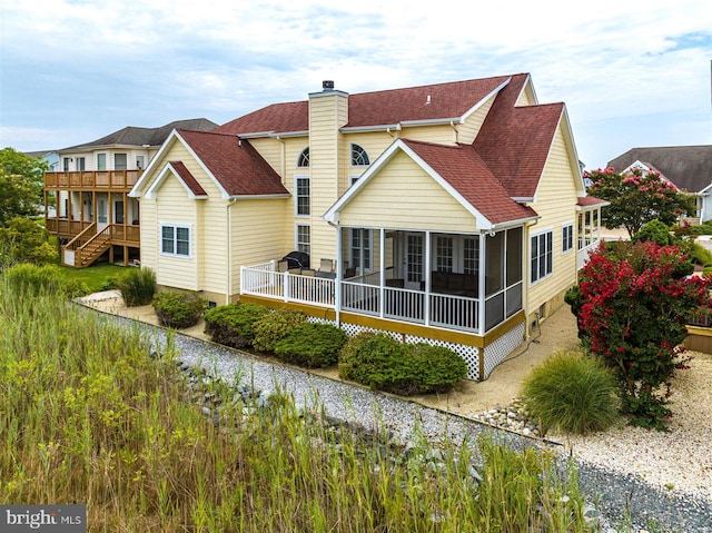 back of house featuring a deck and a sunroom