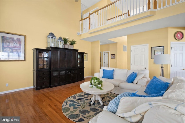 living room with a high ceiling and hardwood / wood-style floors