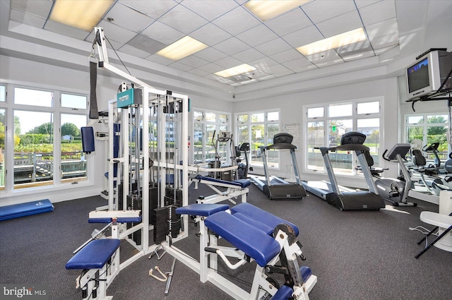 gym with a drop ceiling and dark carpet