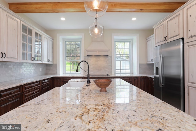 kitchen featuring dark brown cabinetry, backsplash, and stainless steel refrigerator with ice dispenser