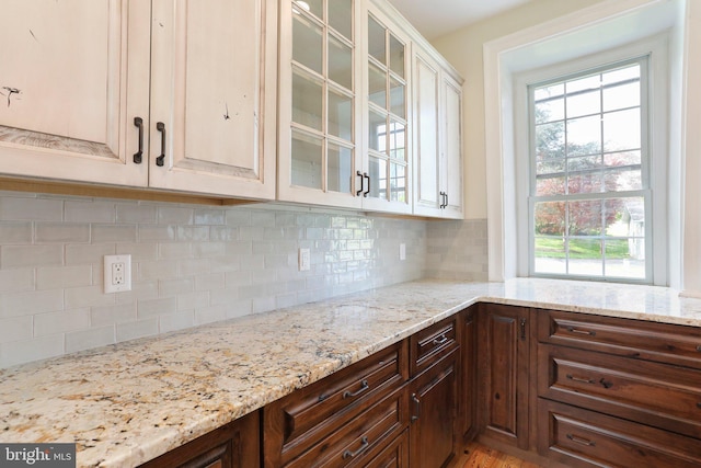 kitchen featuring plenty of natural light, tasteful backsplash, and light stone countertops