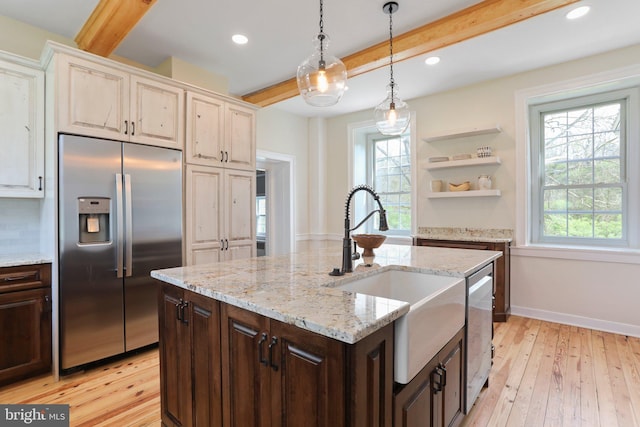 kitchen featuring dark brown cabinets, hanging light fixtures, stainless steel appliances, beam ceiling, and light wood-type flooring