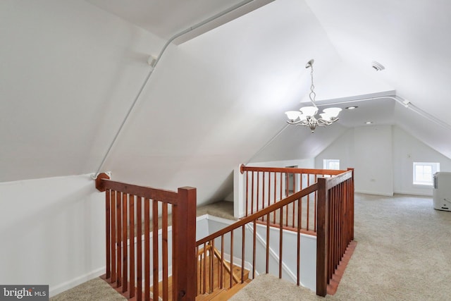 stairs featuring an inviting chandelier, light carpet, and vaulted ceiling